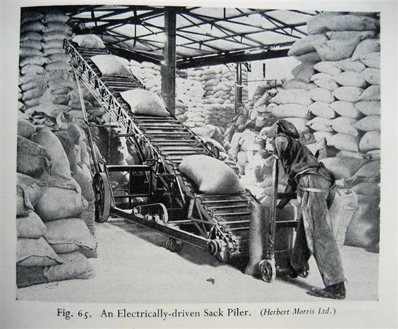 In the early 1900s, factory workers were experiencing an increasing availability of material handling implements such as this hand truck and electrically-driven sack piler.